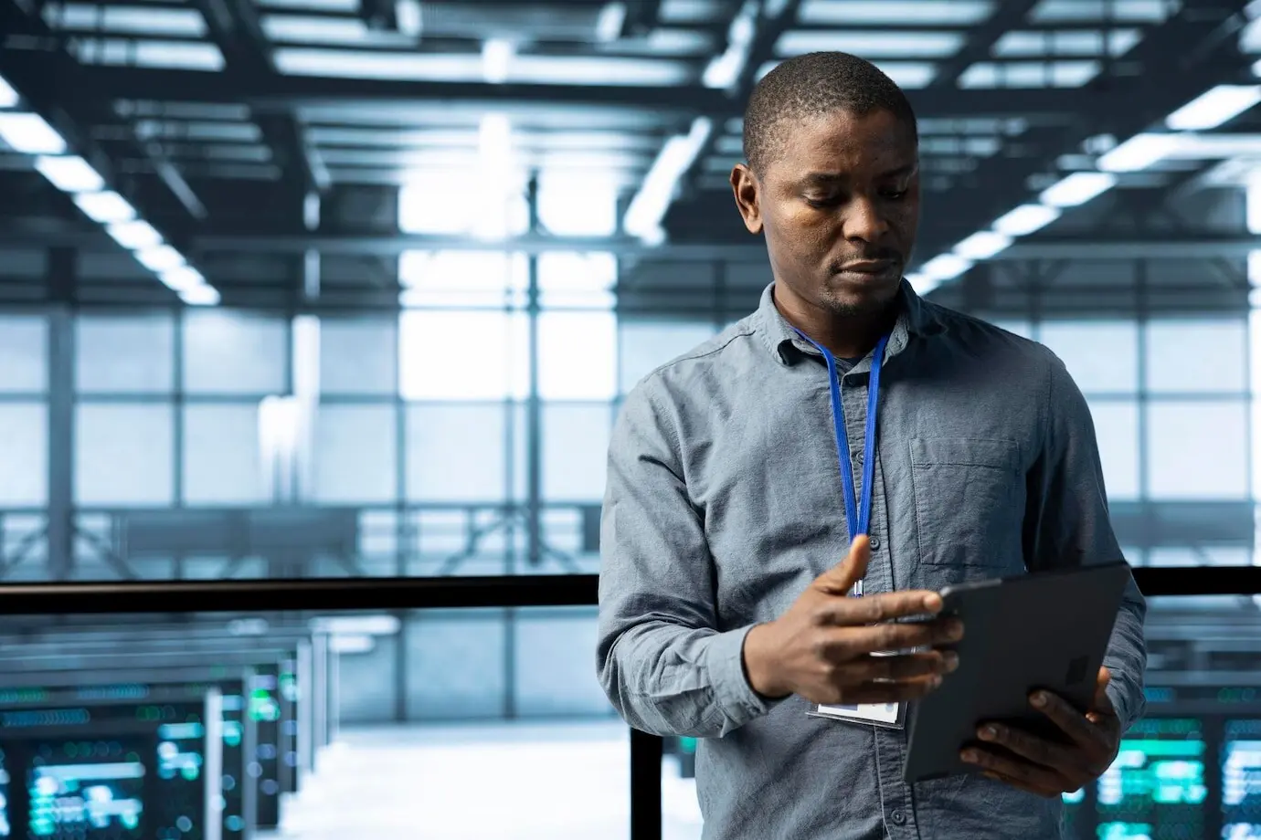 Специалист по информатике в дата-центре использует планшет для проверки соответствия стоек.